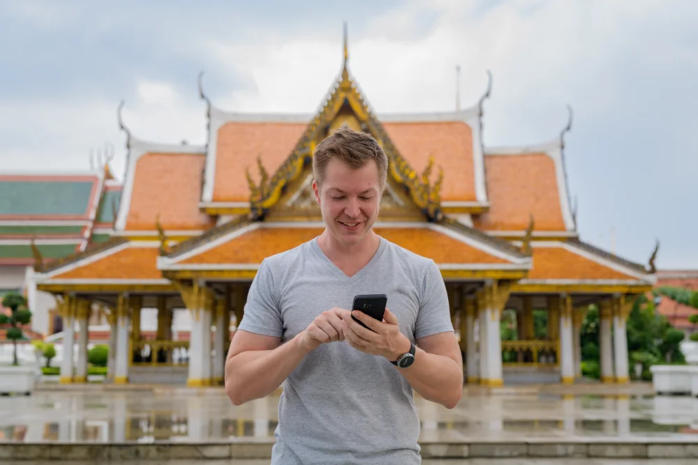 Touristen Paar steht mit Gepäck vor dem Bangkok Flughafen Eingang in Thailand.